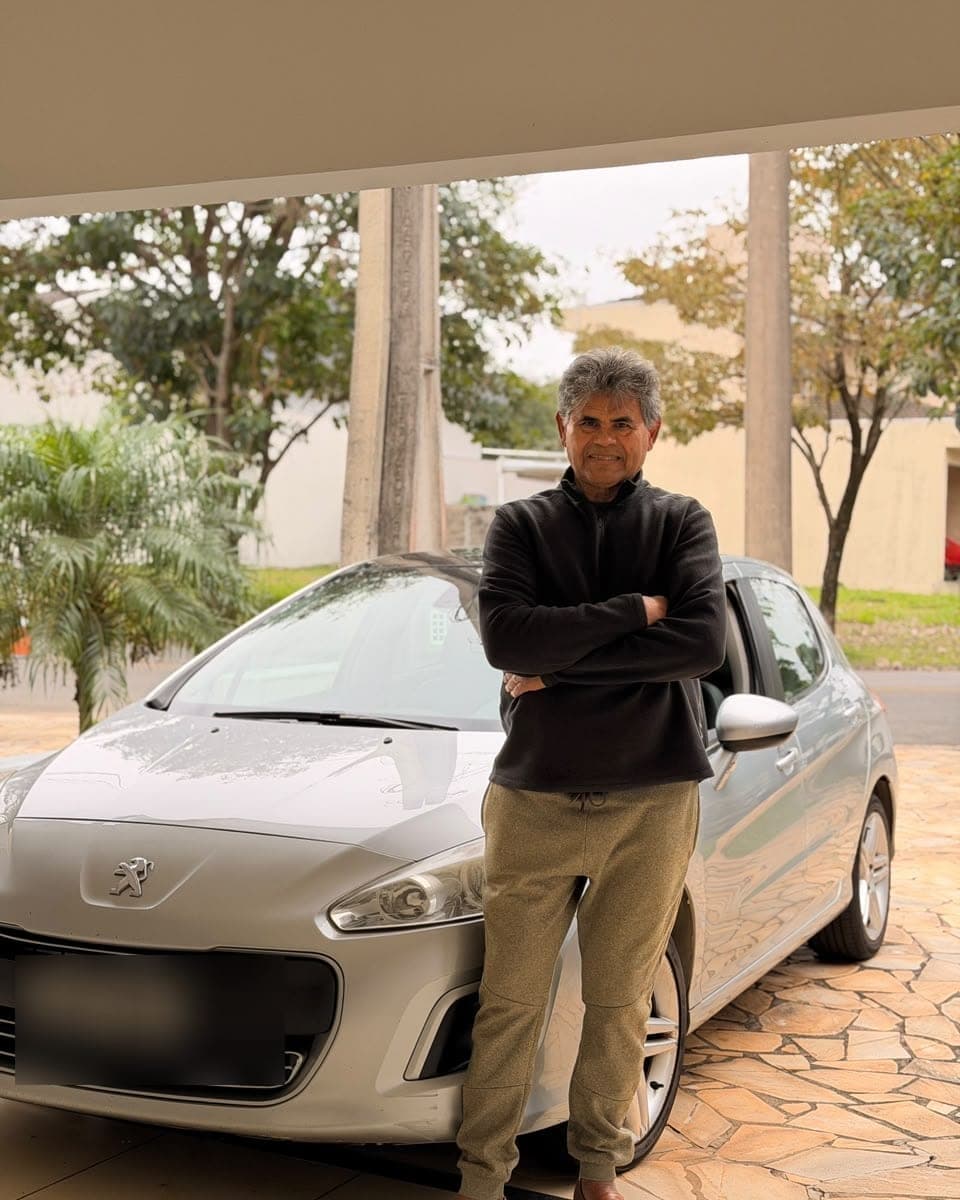Benedito ao lado do carro, sorrindo para a câmera